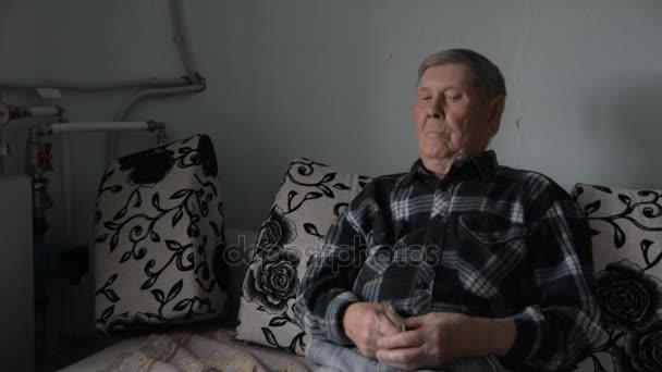 Gamla farfar tittar fundersamt åt sidan — Stockvideo