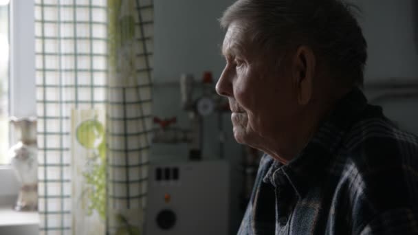 Старый дед задумчиво смотрит в сторону сидит — стоковое видео