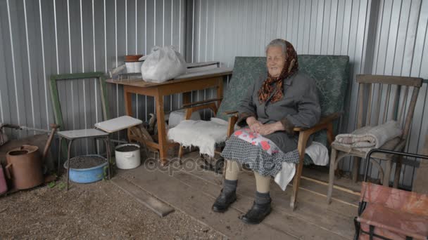 Velha avó sentada em uma poltrona ao ar livre sorrindo — Vídeo de Stock