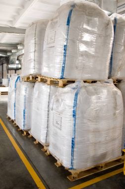 Toplu malzeme paletler üzerinde beyaz büyük konteynerler