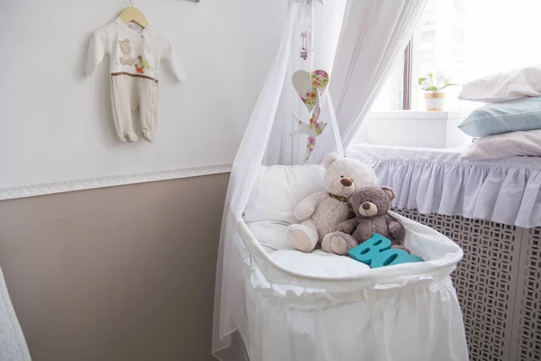 เตียงเด็กทารกกับหมีเท็ดดี้ในห้อง — ภาพถ่ายสต็อก
