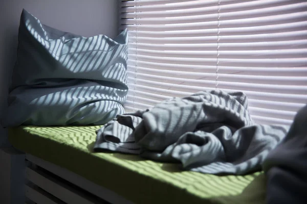Travesseiro no peitoril da janela é iluminado através — Fotografia de Stock