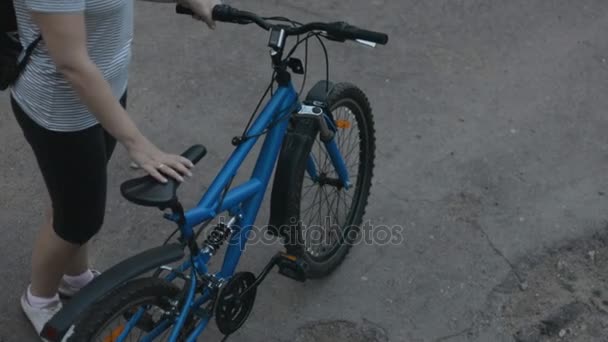 Kvinna i en randig blus rider en cykel — Stockvideo