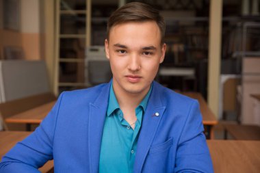 Mavi elbiseli bir genç başarılı adam portresi.