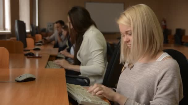 Porträt einer fröhlichen Studentin, die am Computer arbeitet — Stockvideo