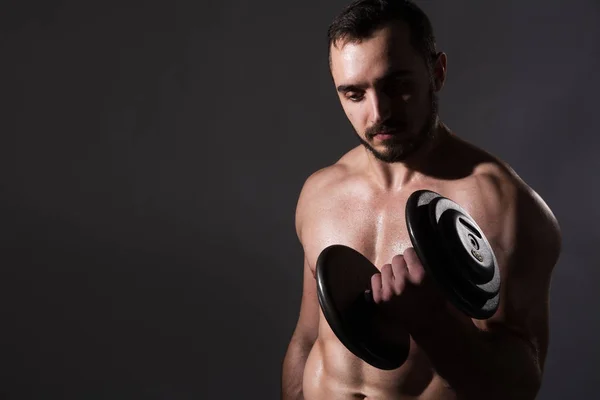 Muscular bodybuilder guy doing exercises with dumbbell — Stock Photo, Image