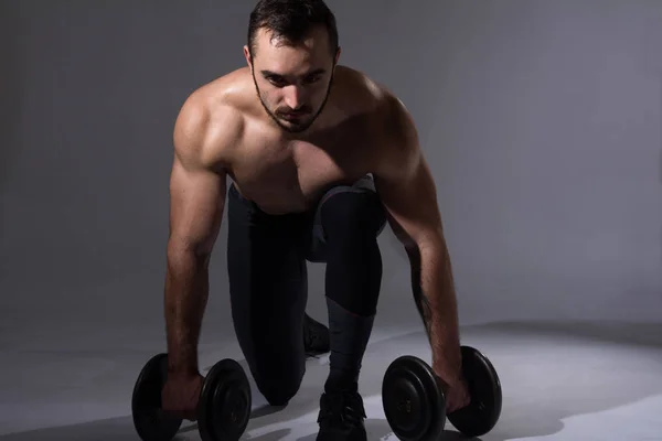 Jovem muscular homem com halteres — Fotografia de Stock