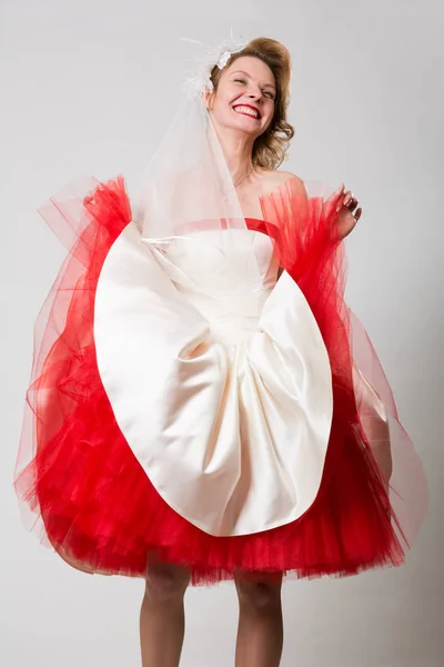 Emotional beautiful bride in a red white dress — Stock Photo, Image