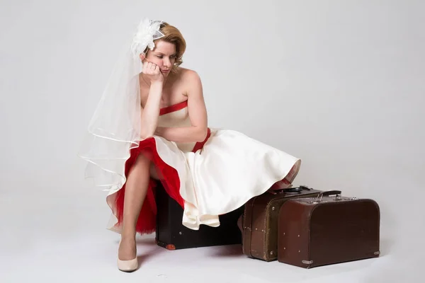 Triste novia con maletas sobre fondo blanco en el estudio —  Fotos de Stock