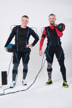 Uyarılması için elektrikli bir kas elbiseli iki adam.