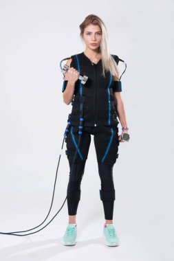 Dumbbells ile uyarılması için elektrik kas elbiseli güzel sarışın