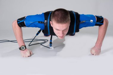 Şınav yumruk üzerinde uyarılması için elektrikli bir kas elbiseli adam yok