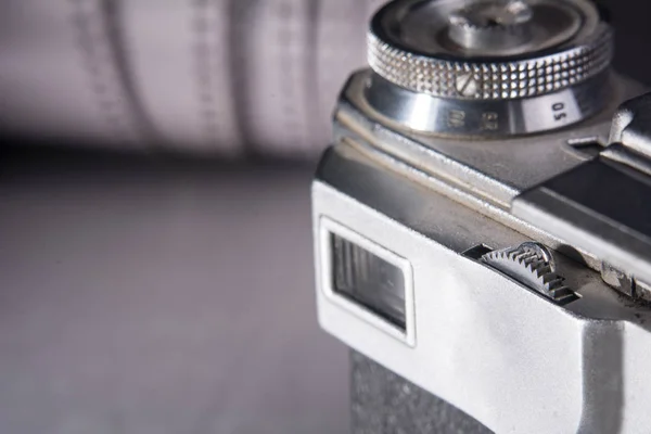 Camera on the background of a roll of negative film — Stock Photo, Image