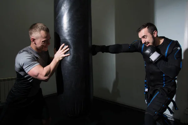 Homme fort en gants de boxe pendant l'entraînement . — Photo