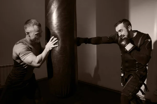 Сильный человек в боксёрских перчатках во время тренировки . — стоковое фото