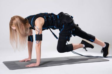 Uyarılması için elektrikli bir kas elbiseli güzel sarışın