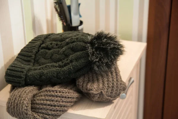 Knitted cap and scarf on the pedestal in the hallway — Stock Photo, Image