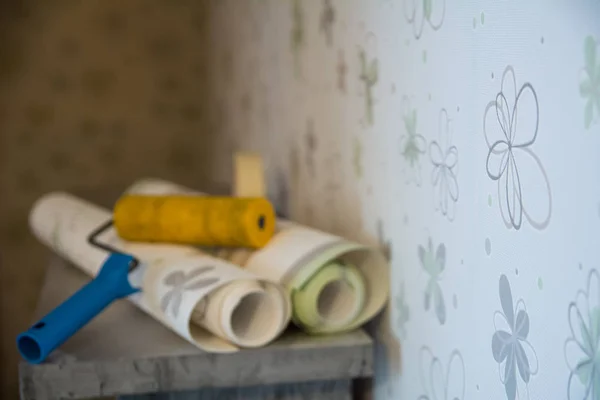 Dos rollos de papel pintado y un rodillo se encuentran en contra — Foto de Stock