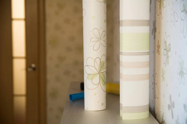 Dos rollos de soporte de papel pintado contra la pared con wallpape floral —  Fotos de Stock