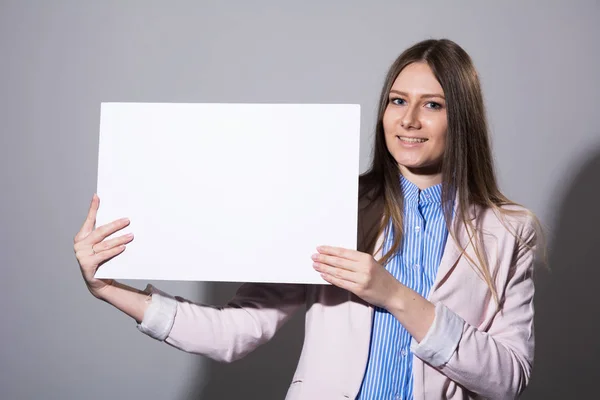 Молодая женщина с чистым листом для рекламы — стоковое фото