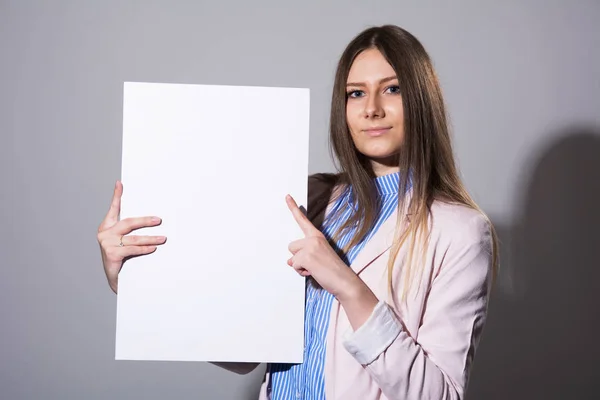 Молодая красивая женщина указывает на чистый лист — стоковое фото