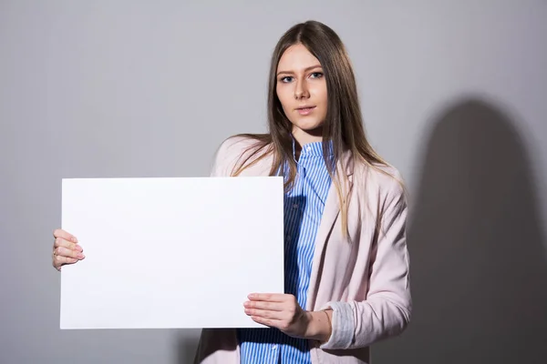 Jonge vrouw in een jasje met een leeg vel — Stockfoto