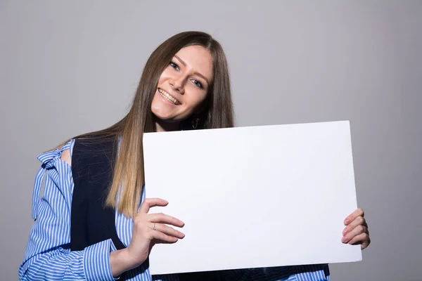 Πορτρέτο του μια νεαρή γυναίκα με ένα κενό λευκό πανό — Φωτογραφία Αρχείου