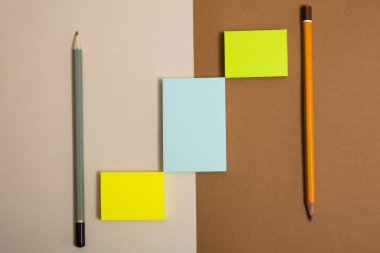 Üç adet çok renkli yapışkan yapışkan kağıt ve iki kalem