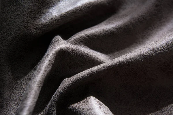 Close-up de um tecido dobrável com uma fatura iluminada pela luz — Fotografia de Stock