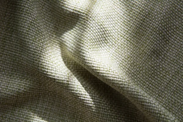 Крупный план сложенной зеленой синтетической ткани с большой нитью — стоковое фото