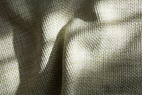 Close-up of a folded green synthetic fabric with a large thread — Stock Photo, Image