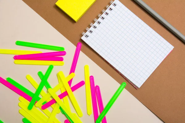 Cuaderno en blanco y un montón de palos de recuento de colores — Foto de Stock