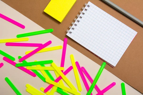 Cuaderno en blanco y un montón de palos de recuento de colores — Foto de Stock
