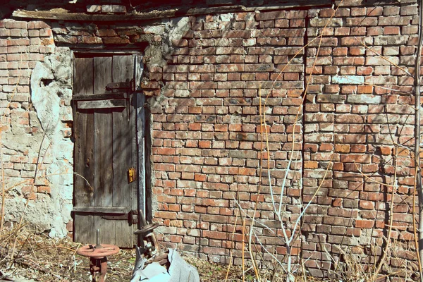 Fondo pared de ladrillo y puerta de madera vieja — Foto de Stock