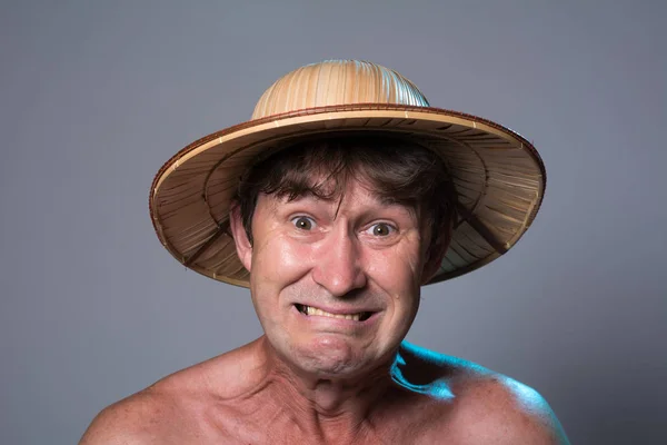 Close-up portrait of an embittered man with a naked torso in a hat — Stock Photo, Image