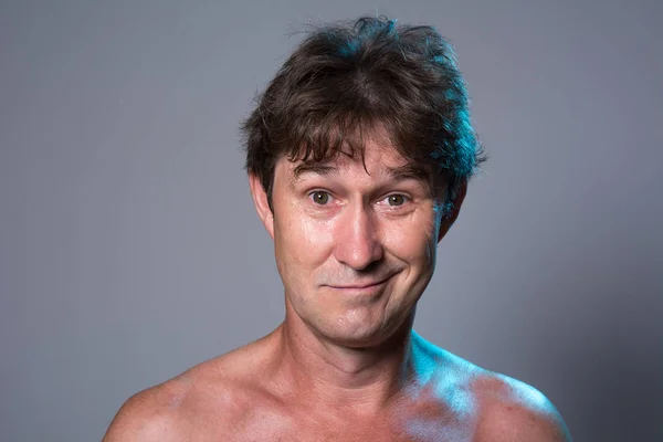 Portrait of a cheerful man with a naked torso on a gray background — Stock Photo, Image