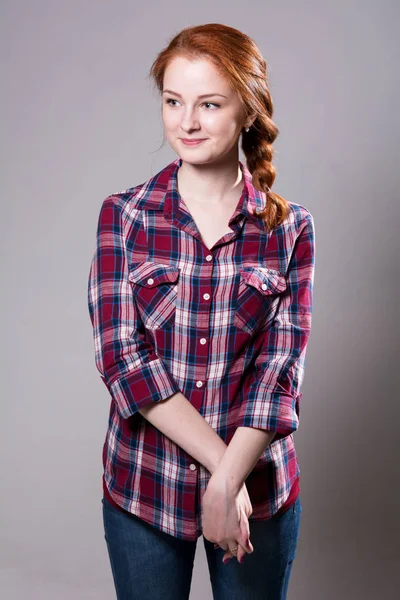 Portret uśmiechający się młodej kobiety w plaid shirt — Zdjęcie stockowe