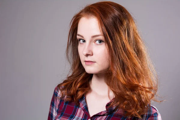 Portret van een serieuze jonge vrouw in een plaid shirt — Stockfoto