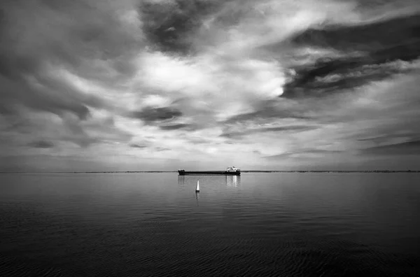 拥有一艘船和美丽的云彩的黑色海景 — 图库照片