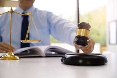 Hukuk danışmanı müvekkiline tokmak ve hukuk hukuku ile imzalanmış bir sözleşme sunar. Adalet ve avukat kavramı