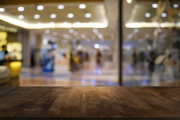 Table en bois sombre vide devant un fond abstrait flou — Photo