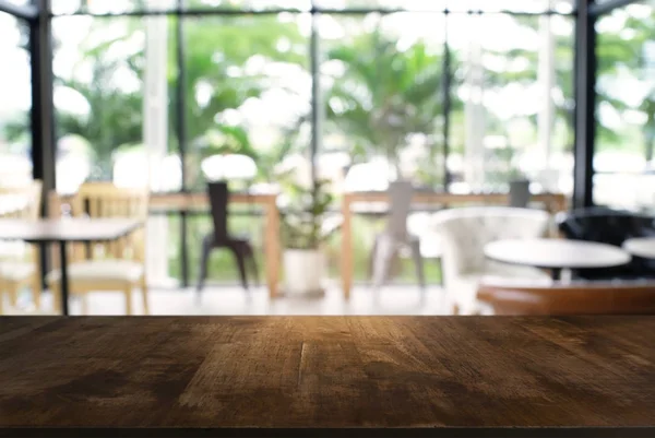 Άδειο σκοτεινό ξύλινο τραπέζι μπροστά από το αφηρημένο θολή φόντο — Φωτογραφία Αρχείου