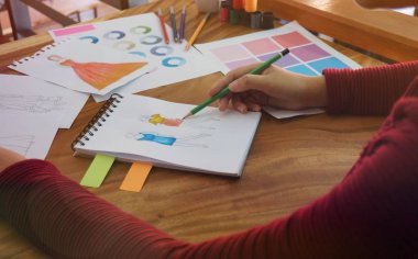 Moda tasarımcısı atölyedeki yeni koleksiyonun taslağı olarak çalışıyor. Yaratıcı Tasarım Konsepti