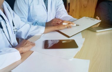 Tıp teknolojisi ekip toplantısı konsepti. Doktor el çalışıyor akıllı telefon modern dijital tablet dizüstü bilgisayar grafikleri arayüzü.