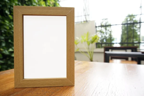 Mock up blank weißer Rahmen steht auf Holztisch in bar restaura — Stockfoto