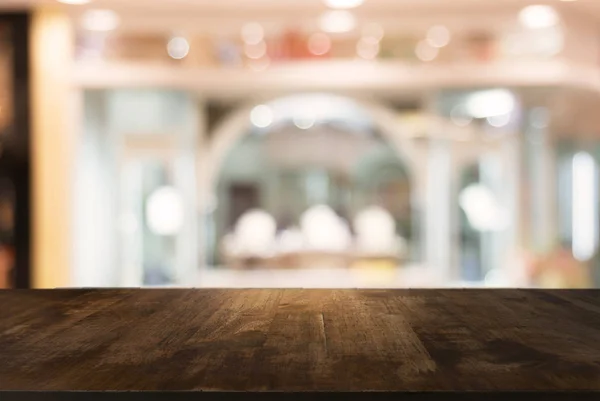 Prázdnou dřevěný stůl před abstraktní rozostřeného pozadí co — Stock fotografie