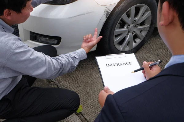 Loss Adjuster Insurance Agent Inspecting Damaged Car selective f