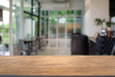 Restoranın soyut bulanık arka planının önündeki boş, siyah ahşap masa. Ürünlerinizi görüntülemek veya montajlamak için kullanılabilir.