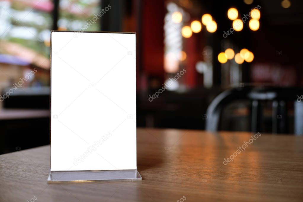 Mock up Menu frame standing on wood table in Bar restaurant cafe. space for text.