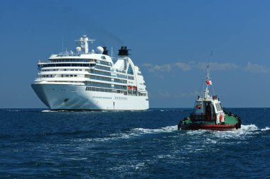 Yolcu gemisi limana geliyor, yanında bir pilot botu var..